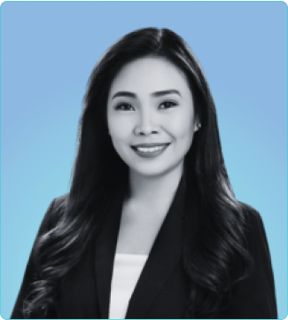 A woman dressed in a business suit poses against a blue backdrop, showcasing professionalism and determination.