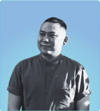 A well-dressed man in a shirt and tie poses in front of a vibrant blue background, showcasing a professional demeanor.