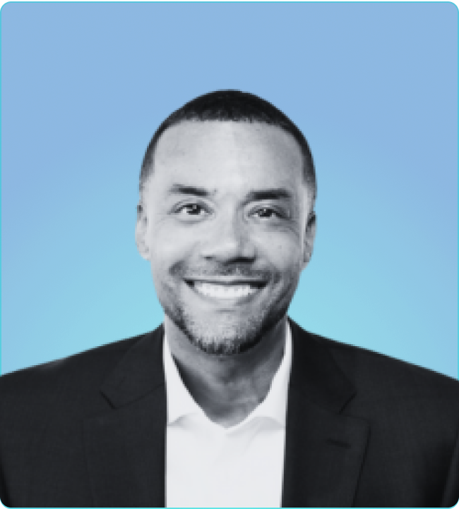 A well-dressed man in a suit and tie displays a warm smile, reflecting confidence and professionalism.